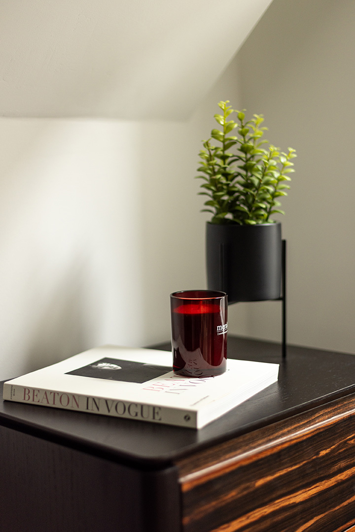 Book, candle, and potted plant on a wooden nightstand-13
