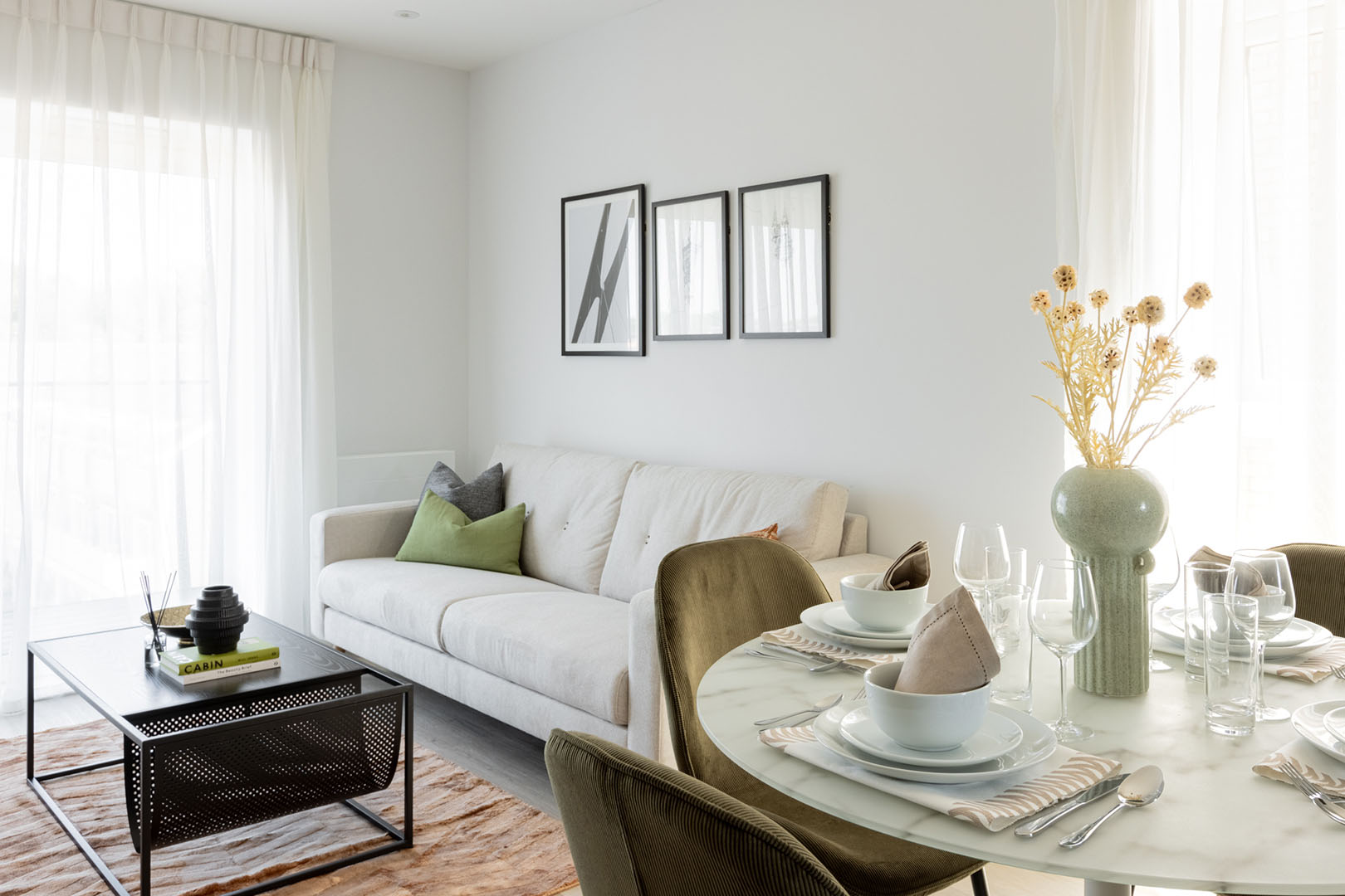 Open-plan living space with a sofa, dining table, and artwork-43
