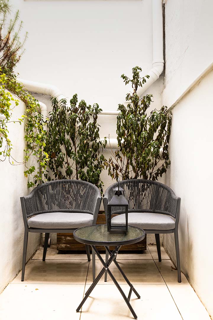 mall patio with greenery, two chairs, and a lantern-03
