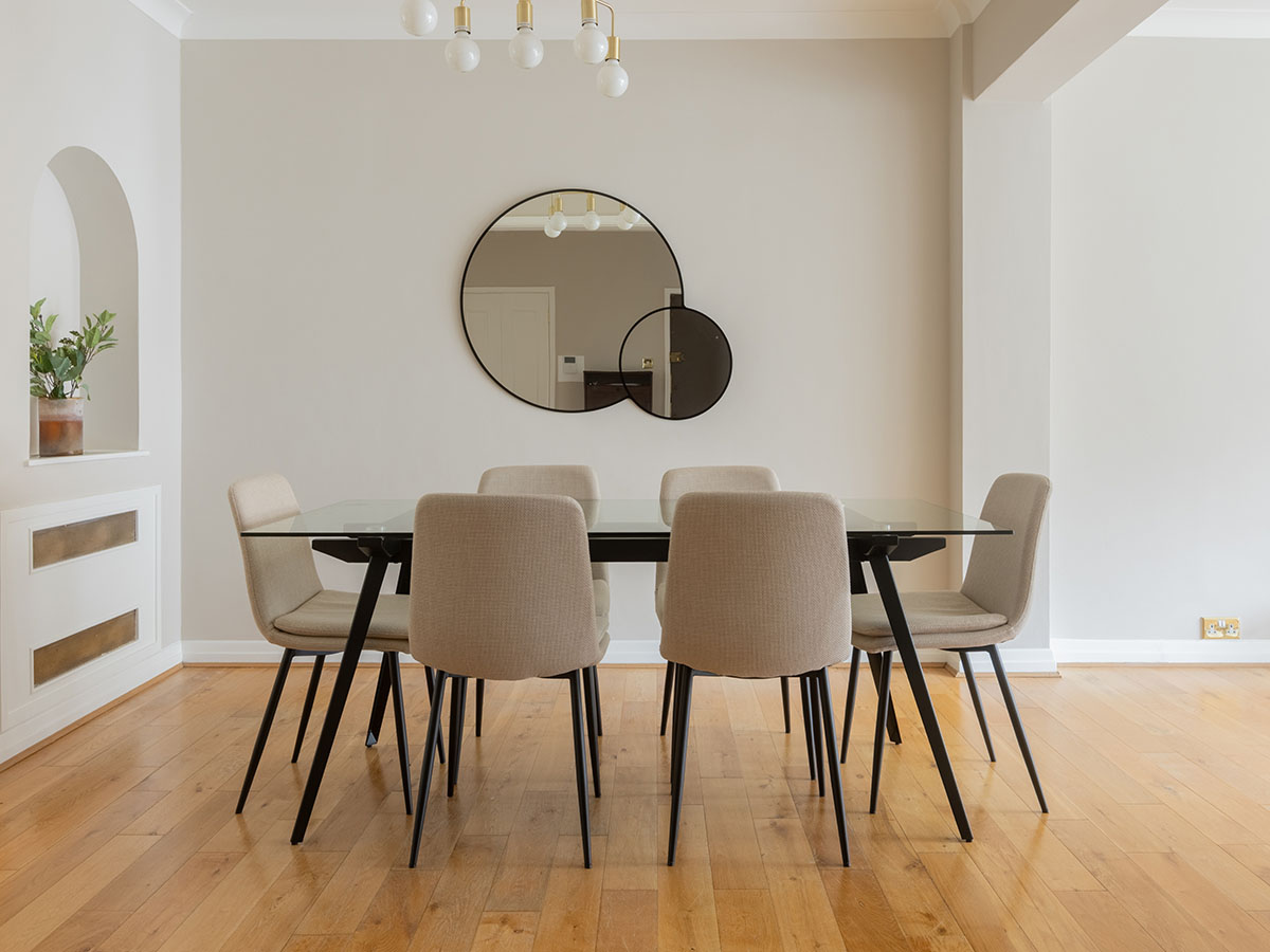 Stylish dining space with round mirrors and six chairs