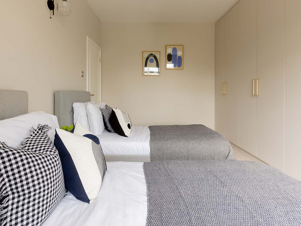 Contemporary twin bedroom featuring built-in wardrobes